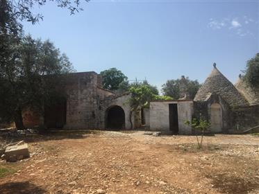 For sale in the countryside of Castellana, a beautiful complex of trulli with lamias and old stables