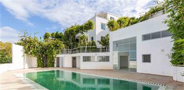 A beautiful modern villa with stunning views of the sea and the city consisting of a main house spre